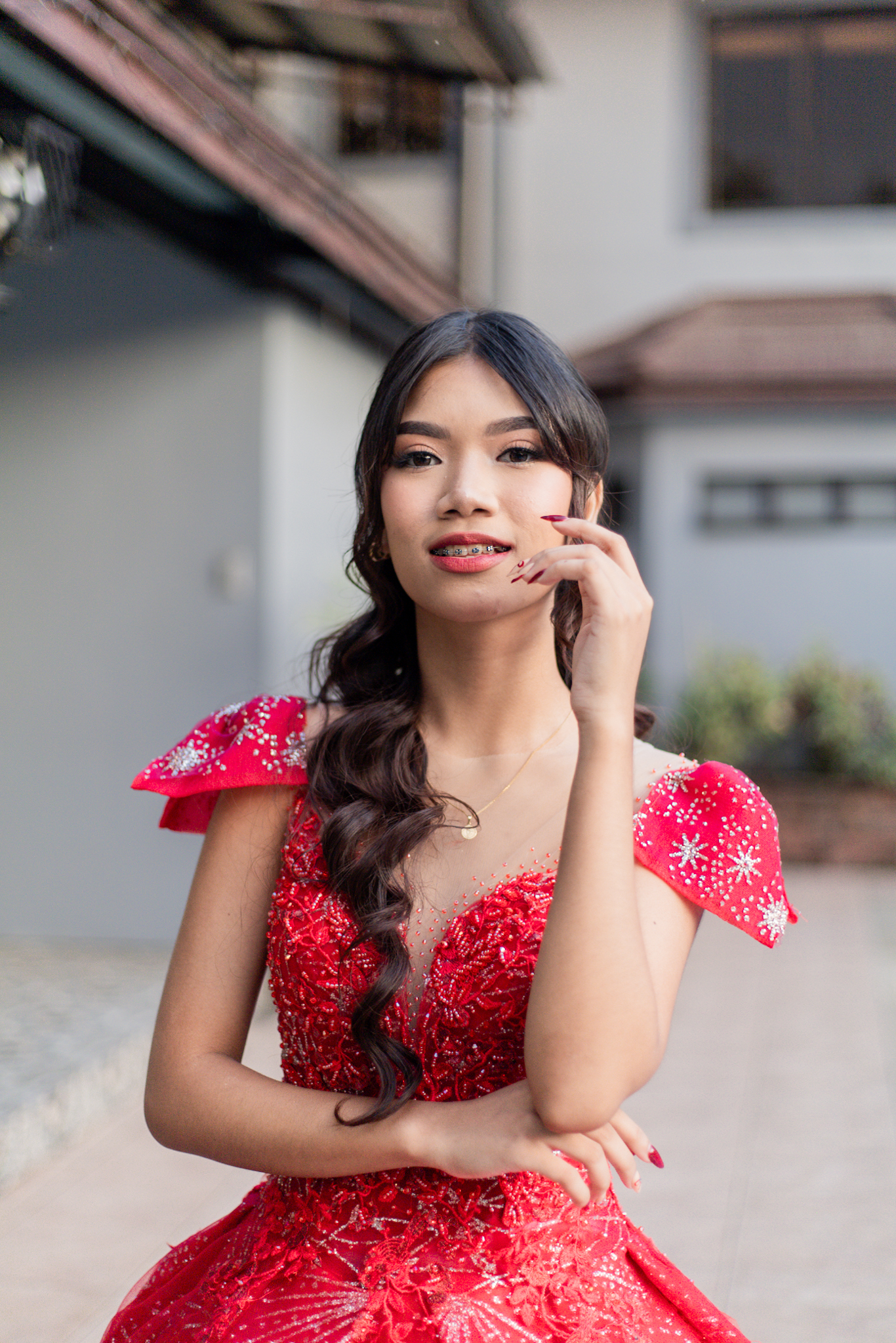 Breathtaking landscape with a model standing on a cliff edge at sunset overlooking mountains and lake with dramatic lighting