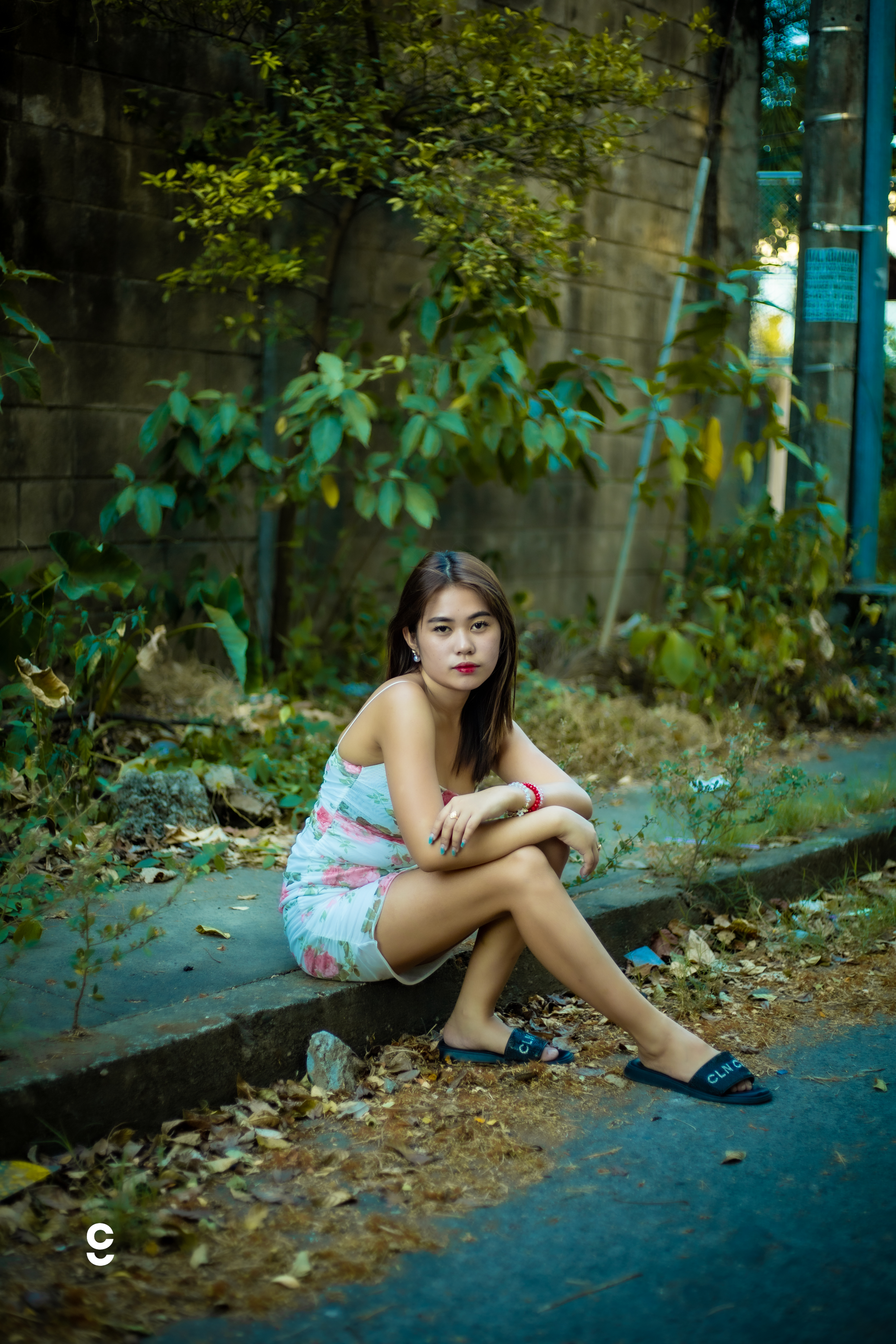 Breathtaking landscape with a model standing on a cliff edge at sunset overlooking mountains and lake with dramatic lighting