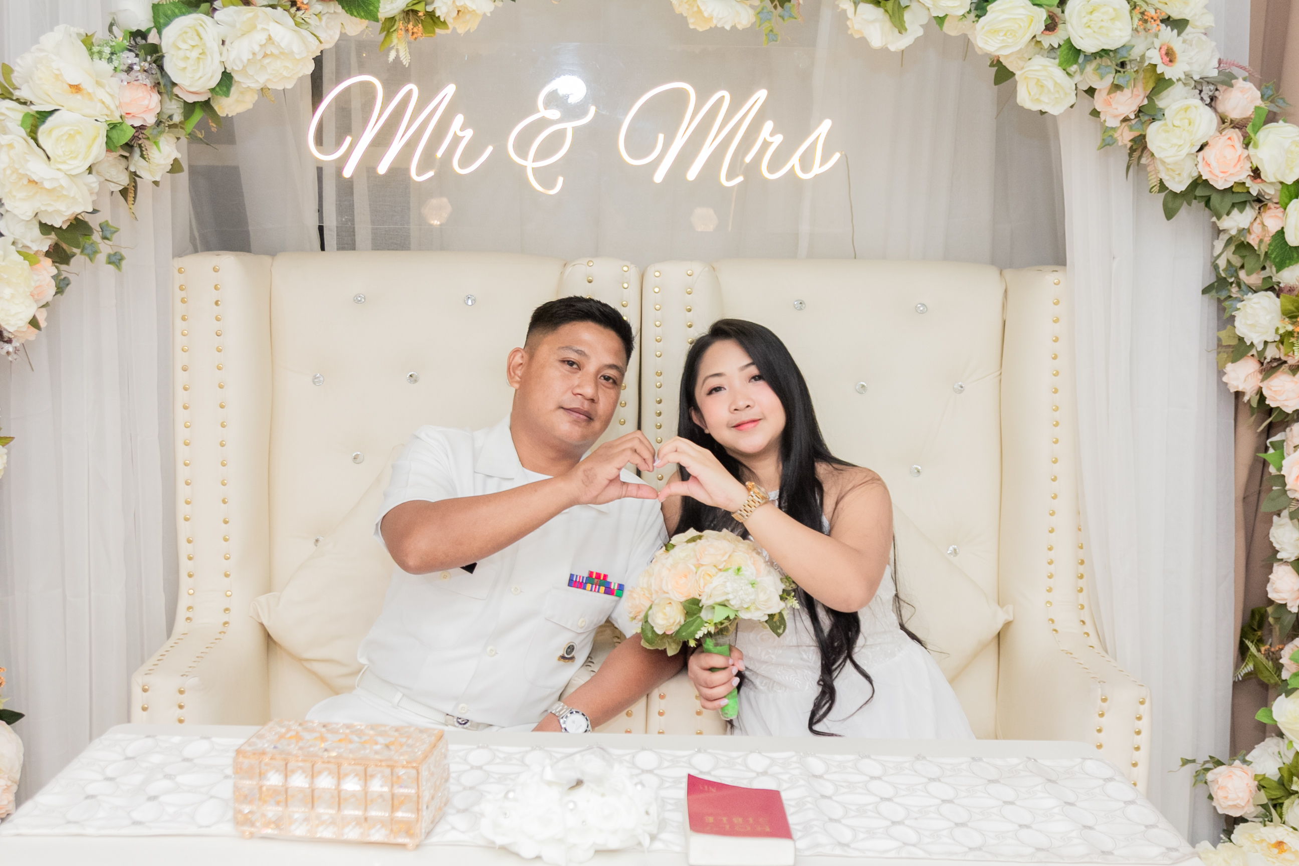 Wedding couple standing at the altar exchanging rings in an elegant church ceremony with soft lighting and floral decorations